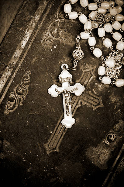 istock crucifix on aged bible, sepia, textured background, 525833659