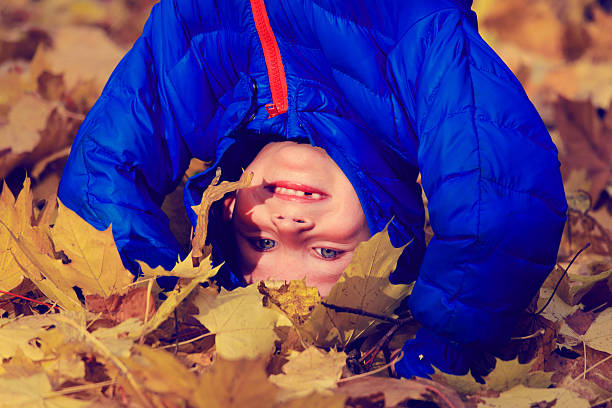 istock happy boy playing in autumn leaves 525834483