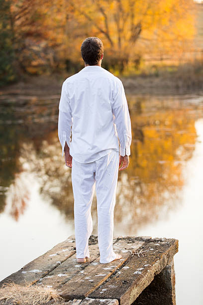 istock young man standing on lake pier 525834761