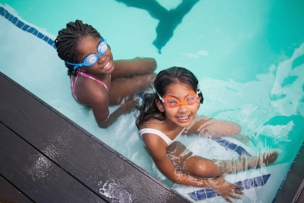 istock Cute little kids sitting poolside 525834891