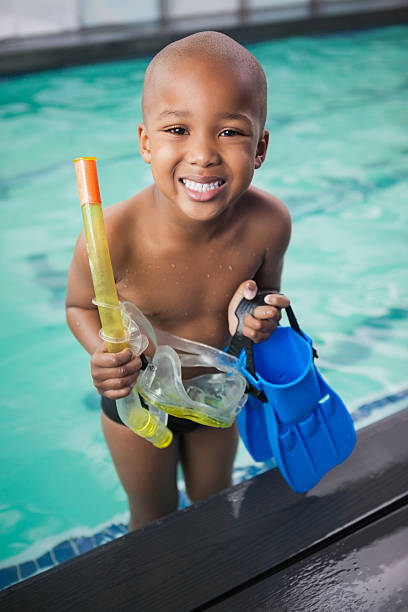 istock Little boy holding flippers by the pool 525834921