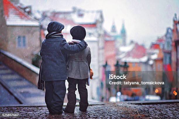 Two Kids Standing On Stairs View Of Prague Behind Them Stock Photo - Download Image Now