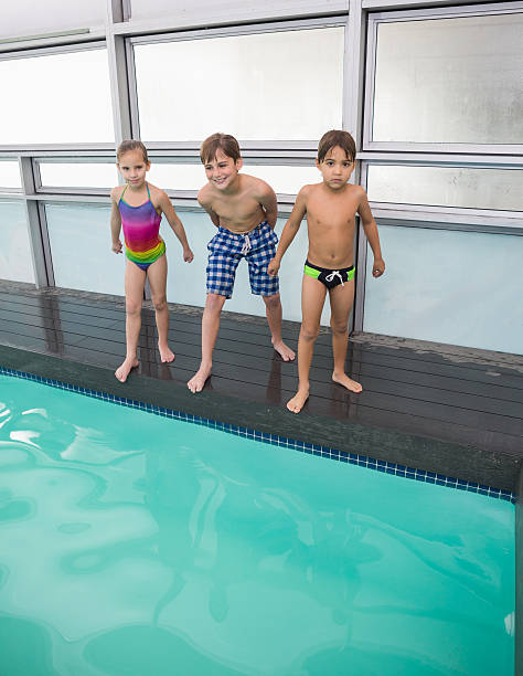 istock Cute swimming class about to jump in pool 525858231