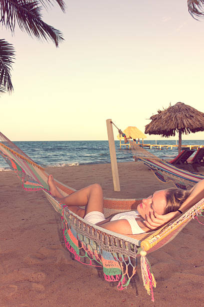 istock Beautiful woman in a hammock on beach, retro looking 525862091