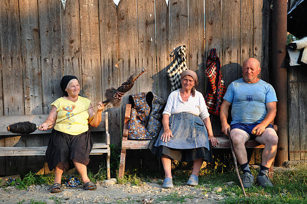 Ieud, Romania - July 14, 2012: Senior people resting on the bench and in a traditional Romanian village from Maramures