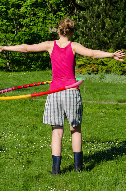 mulher volta spin hula hoop anel na cintura no jardim - slenderize imagens e fotografias de stock