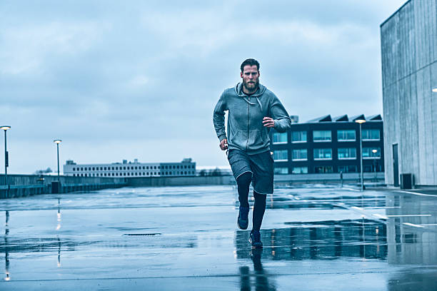 istock Runner makes his way on wet streets after rain 525877208