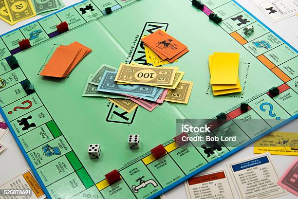 Monopoly Game In Play Money Dice Pieces And Cards Stock Photo - Download Image Now