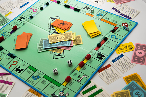 Houston, TX, USA - November 1, 2014: Monopoly board game in play with money, property cards, houses, hotels and dice