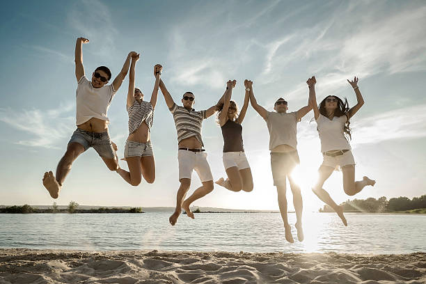 istock Friends jumping on the beach under sunset sunlight. 525878816