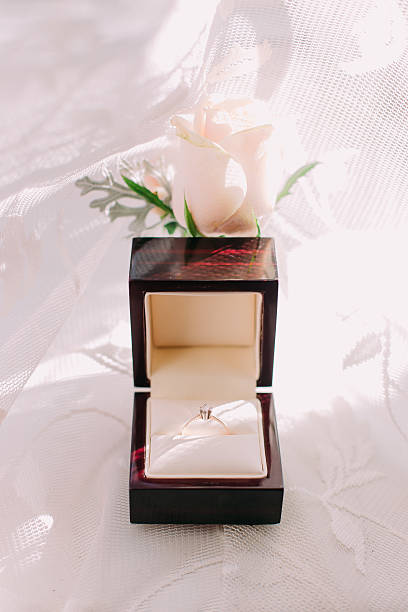 istock Golden wedding ring in box and rose flowers on the 525878842