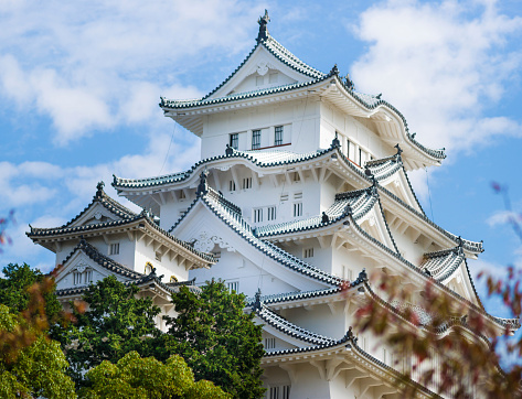 Himeji, Japan - October 24th, 2014: Autumn had arrived to Himeji-jo Castle. Himeji Castle is a hilltop Japanese castle complex located in Himeji, in Hyōgo Prefecture, Japan. The castle is regarded as the finest surviving example of prototypical Japanese castle architecture, comprising a network of 83 buildings with advanced defensive systems from the feudal period.