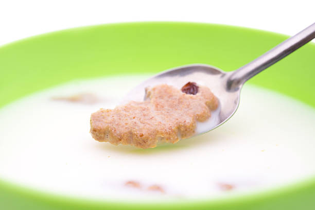 Corn flakes in a red bowl on a white background. Delicious sweet breakfast. Nutrition and health concept