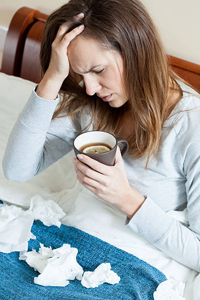 istock Woman with runny nose in bed 525883505