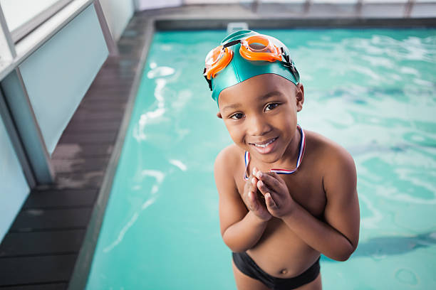 bonito rapaz com a medalha na piscina - swimming child swimwear little boys imagens e fotografias de stock