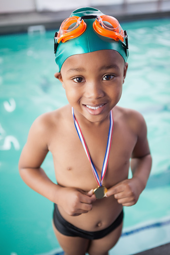 Cute little boy with his medal at the pool at the leisure center
