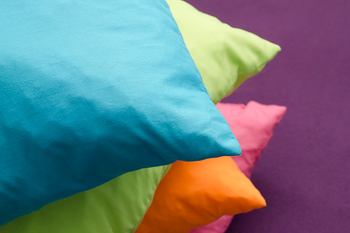 Colorful pillows one on the top of the other. Photo is taken with dslr camera indoors.