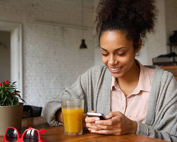 istock Smiling young woman looking at mobile phone 525884777