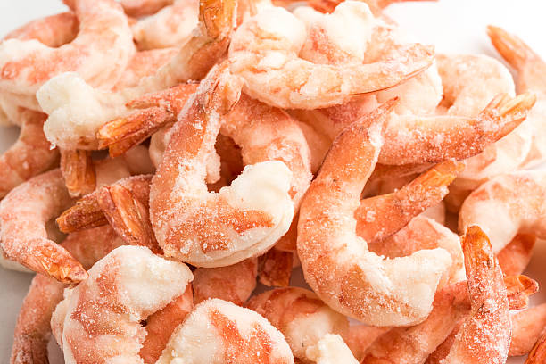 Frozen peeled shrimps Frozen peeled shrimps on white background frozen food stock pictures, royalty-free photos & images