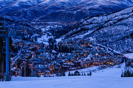 Beaver Creek Village at Dusk - Scenic view from ski slopes looking down with Avon, Colorado in background.  Ski resort area with town lit up in evening dusk blue light.  Beaver Creek, Colorado USA.