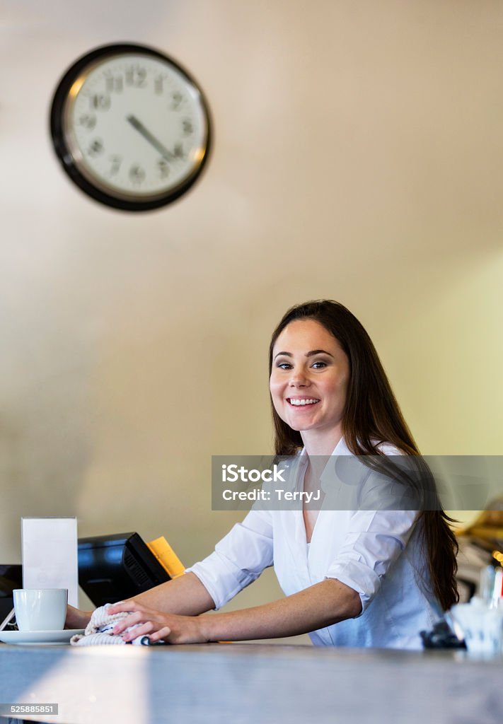 Young Woman Cleans the Counter at a Cafe A young woman wipes a counter top at a cafe. Clock Stock Photo