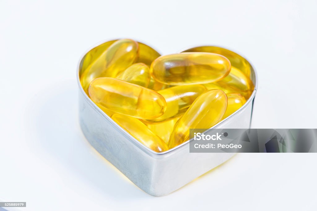 Fish Oil pills on heart   isolated Fish Oil pills on heart   closeup isolated on white background Abstract Stock Photo