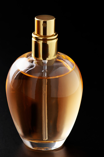 Bottle of woman perfume on dark background.