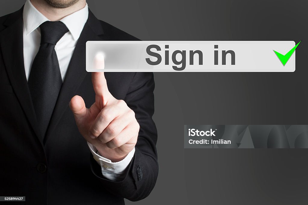 businessman pushing button sign in businessman in black suit pushing button sign in Log On Stock Photo