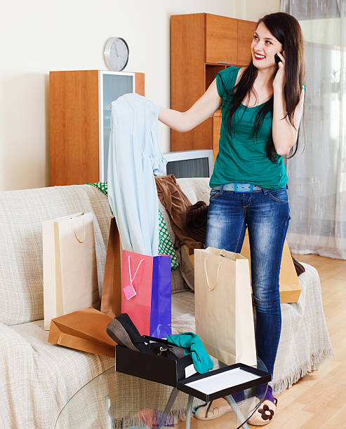 istock Happy woman with purchases  speaking by mobile 525894535