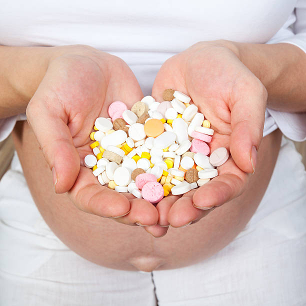 schwangere frau mit pillen - medicine human pregnancy addiction prescription medicine stock-fotos und bilder