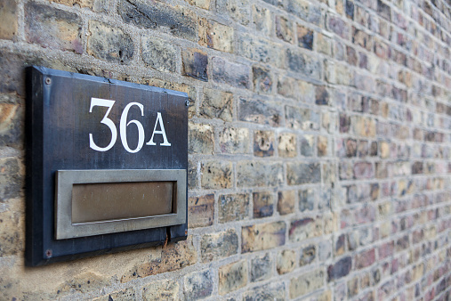 mailbox on brick wall with number on (36a)
