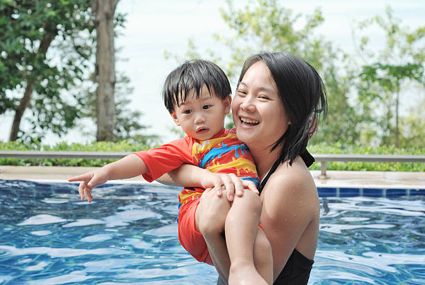 istock Mother and her son Playing in the pool 525895195