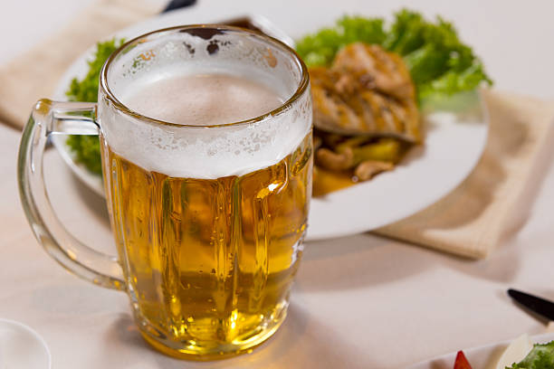istock Close up Mug of Beer Beside Main Dish 525897055