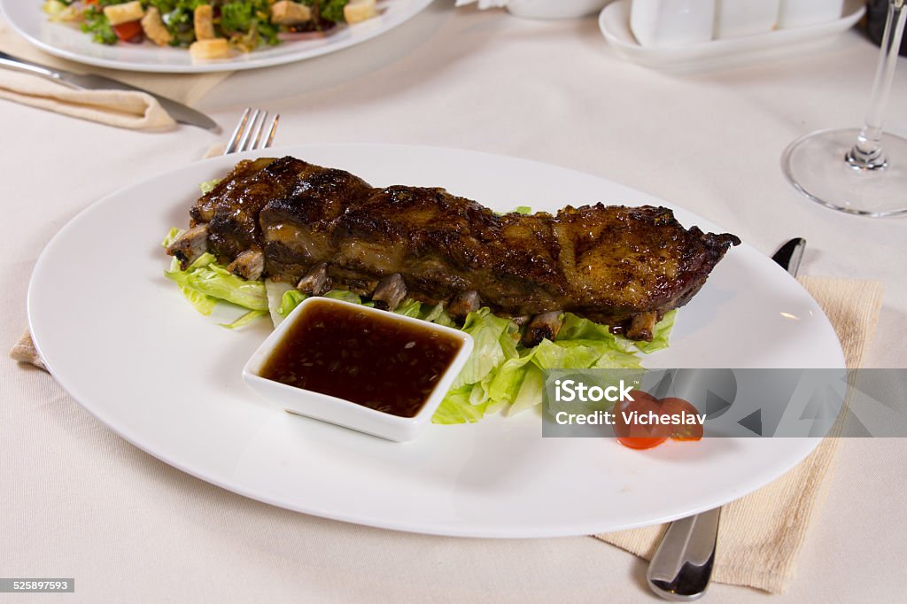 Plate of Ribs with Dipping Sauce Plate of Ribs with Dipping Sauce on Restaurant Table Affectionate Stock Photo