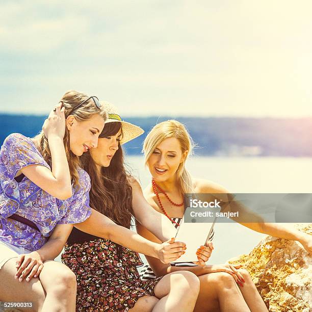 Teenage Girls Using Digital Tablet On The Beach Stock Photo - Download Image Now - 20-24 Years, Adult, Beach