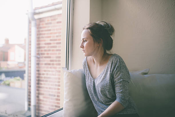 istock Blonde girl looking out of window 525914287