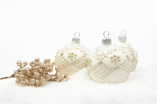 istock Many white christmas baubles with gold decoration on snow 525914289