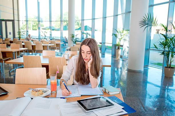Girl studying in the University canteen with Fresh and cake