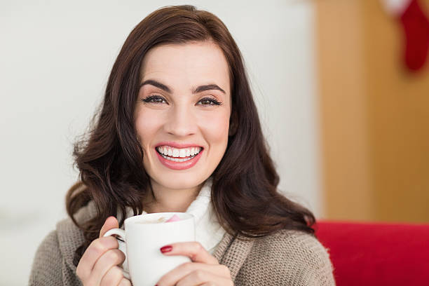 istock Smiling brunette enjoying a hot chocolate with marshmallow 525917515