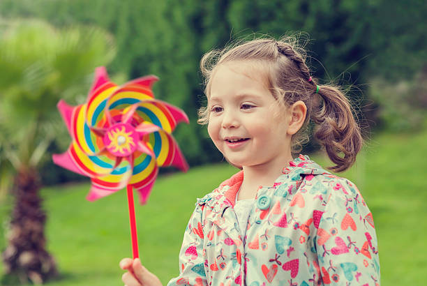 istock little cute girl playing with pinwheel in nature 525917921