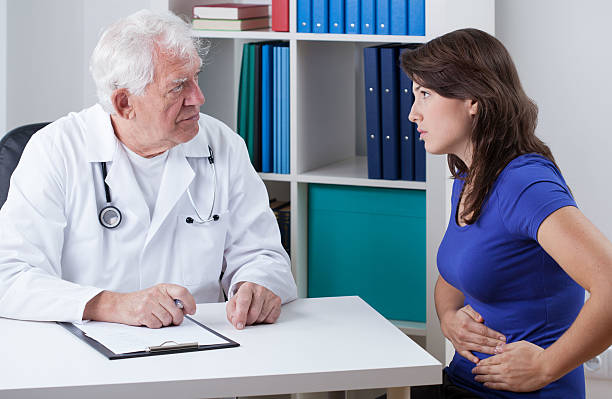 jeune femme avec maux d'estomac - general practitioner photos et images de collection