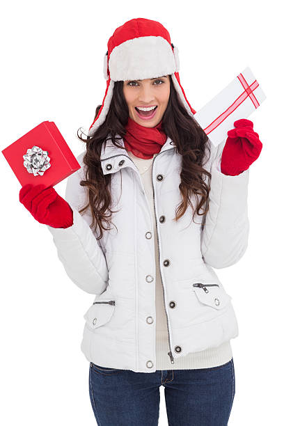 istock Festive brunette in winter clothes holding gifts 525919191