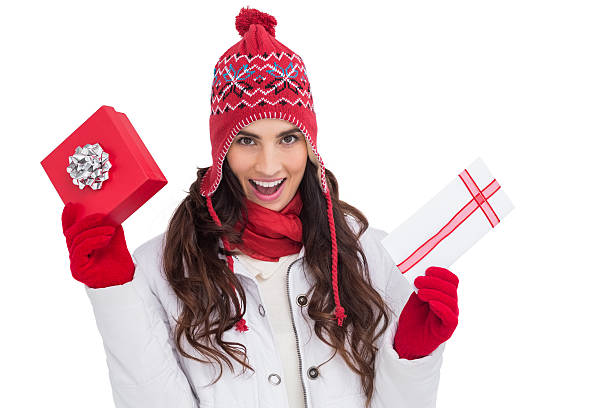 istock Festive brunette in winter clothes holding gifts 525919195