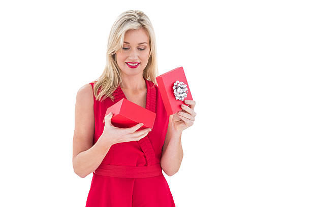 istock Stylish blonde in red dress opening gift box 525919999