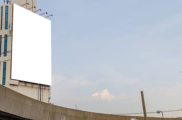 istock large blank billboard on road with city view background 525920283