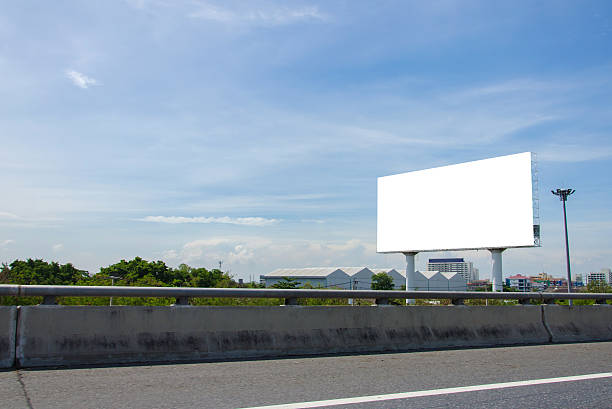 istock large blank billboard on road with city view background 525934913