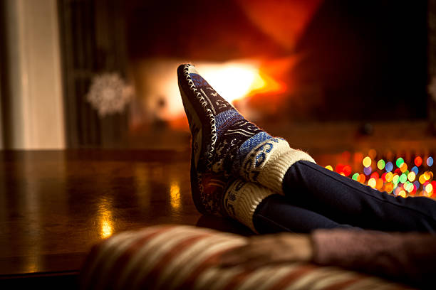 istock feet at woolen socks warming at fireplace in winter 525936989