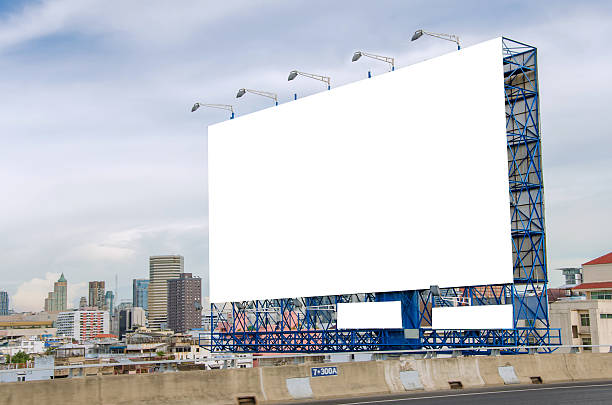istock large blank billboard on road with city view background 525937269