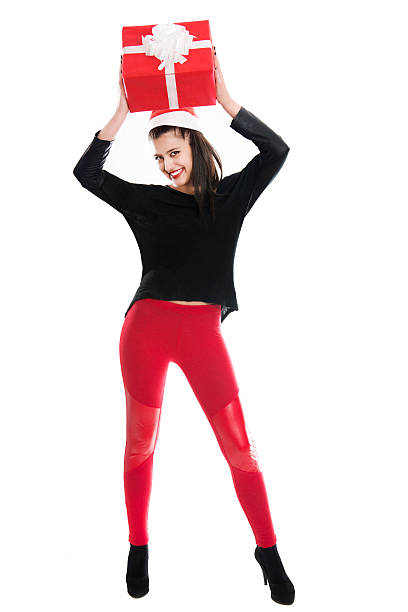istock Attractive Santa Girl with Hat and Heels Holding Gift Box 525940573