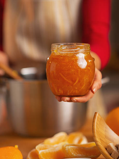 istock closeup on young housewife showing orange jam 525940851